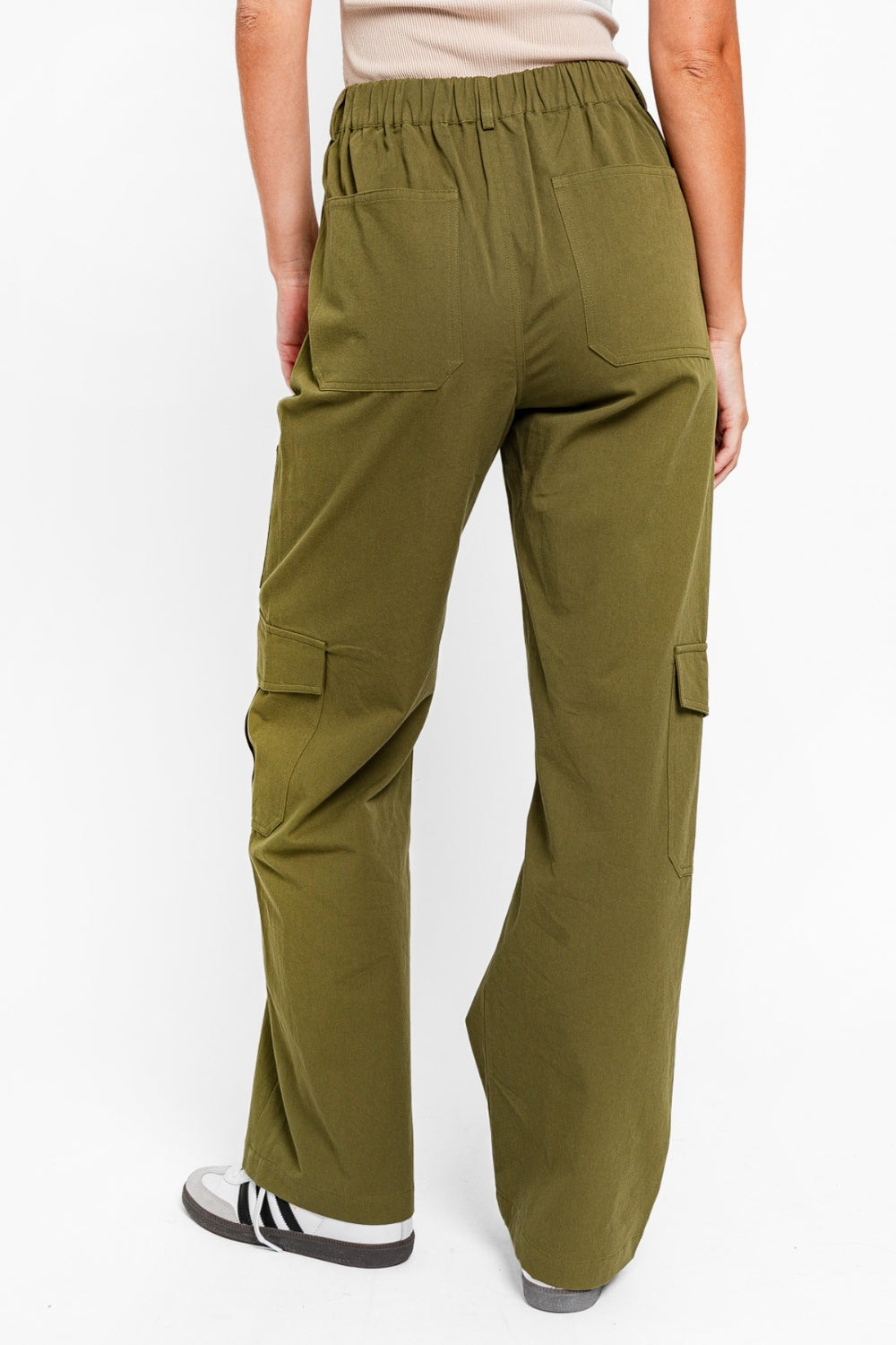   Person wearing the Le Lis High Waisted Wide Leg Cargo Pants with Pockets, featuring side pockets and zipper details, standing against a plain white background.