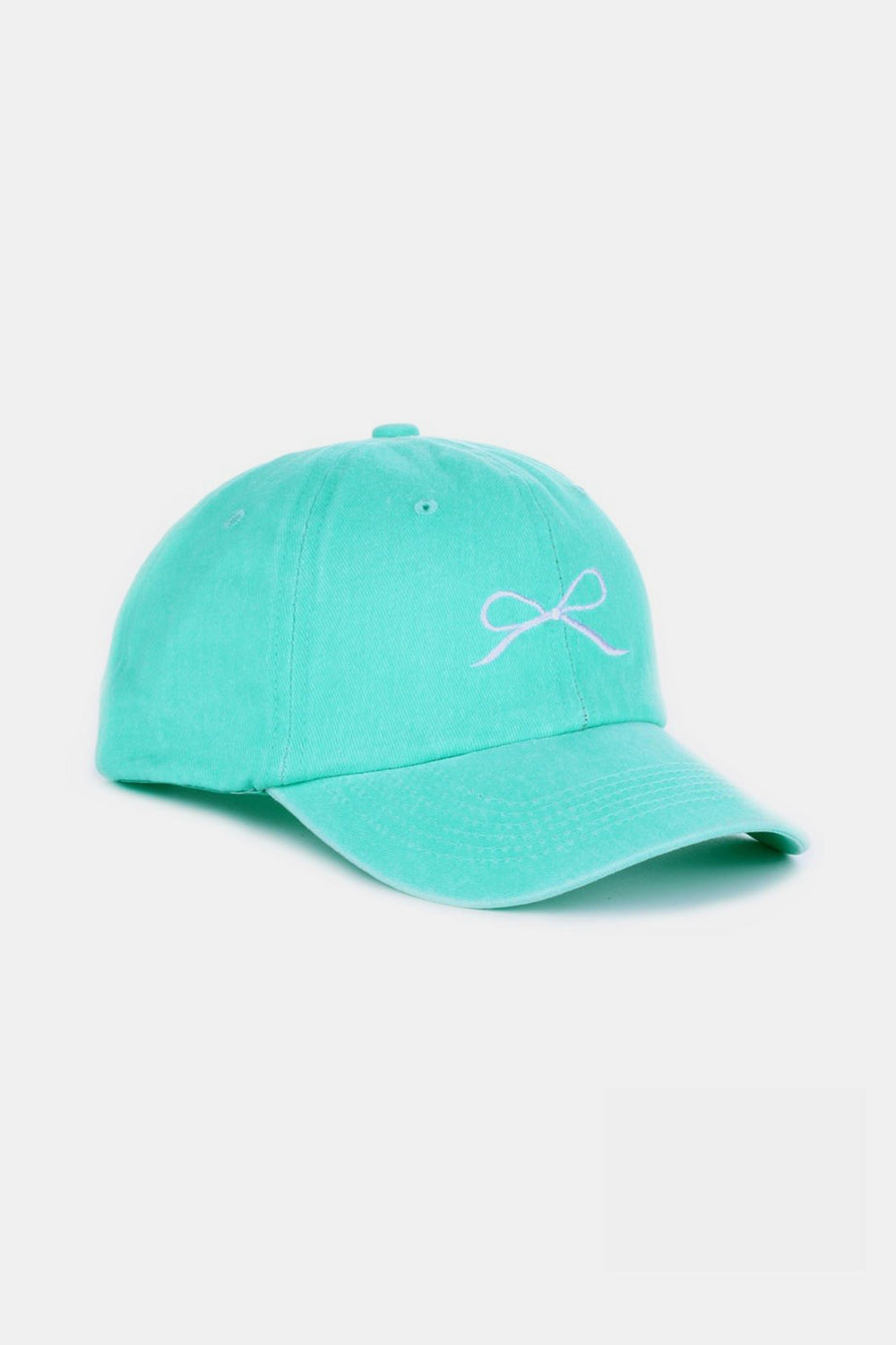 The Zenana Bow Embroidered Washed Cotton Cap features a pink design with a stylish white bow on the front, set against a plain, light background. This chic accessory seamlessly combines elegance and sportiness.