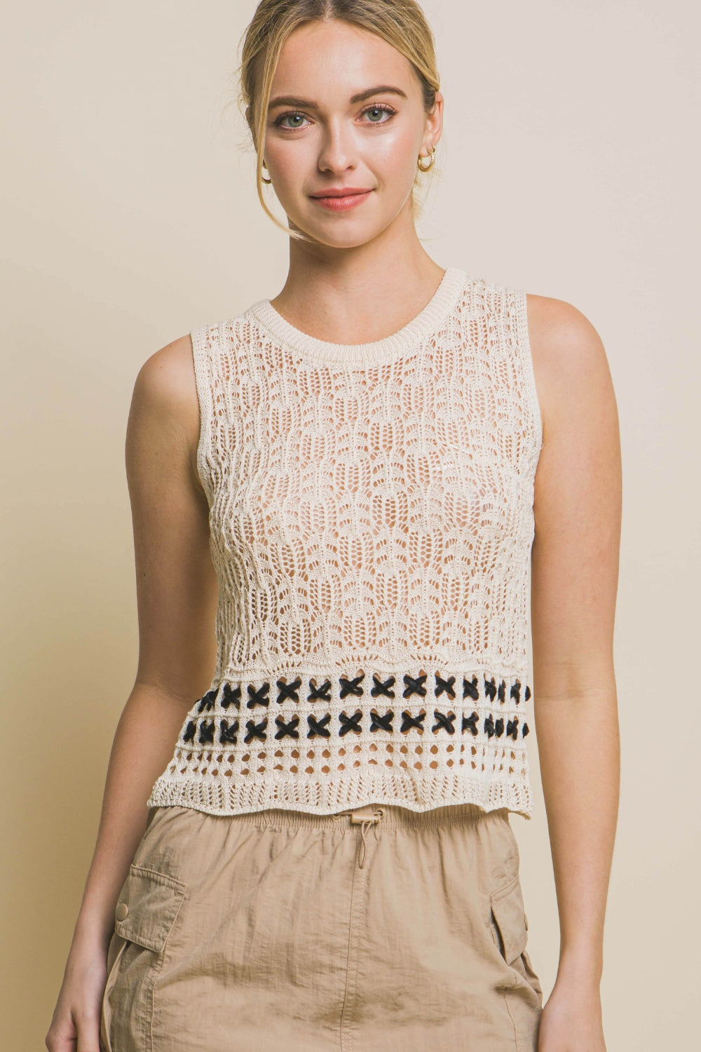 A woman wears the Love Tree Contrast Line Openwork Knit Tank, paired with beige cargo pants, against a plain background.