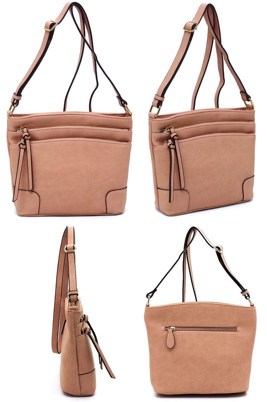 The Fashion Multi Zip Pocket Crossbody Bag is a beige faux leather handbag featuring gold hardware, a front zipper pocket, a two-tone adjustable shoulder strap, and two tassels.