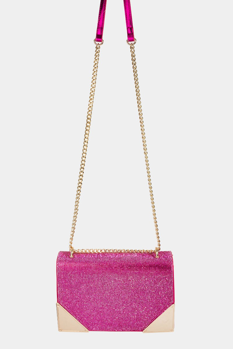 The Fame Rhinestone Studded Rectangle Crossbody Bag is a glamorous pink shoulder bag featuring a gold chain strap and metal corners, making it the perfect medium PU bag to add a touch of elegance to any outfit.