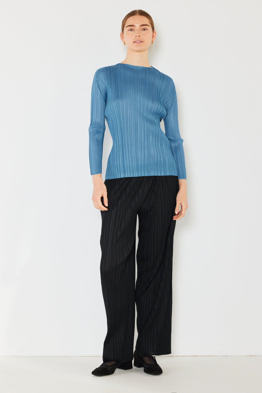 A person wearing the Marina West Swim Pleated Long Sleeve Boatneck Top with matching pants stands against a plain background.