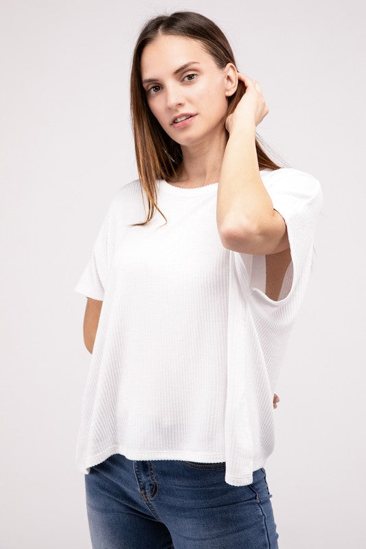 A person with long hair is wearing a Ribbed Striped Oversized Short Sleeve Top in green and white, paired with blue jeans, standing against a plain background.