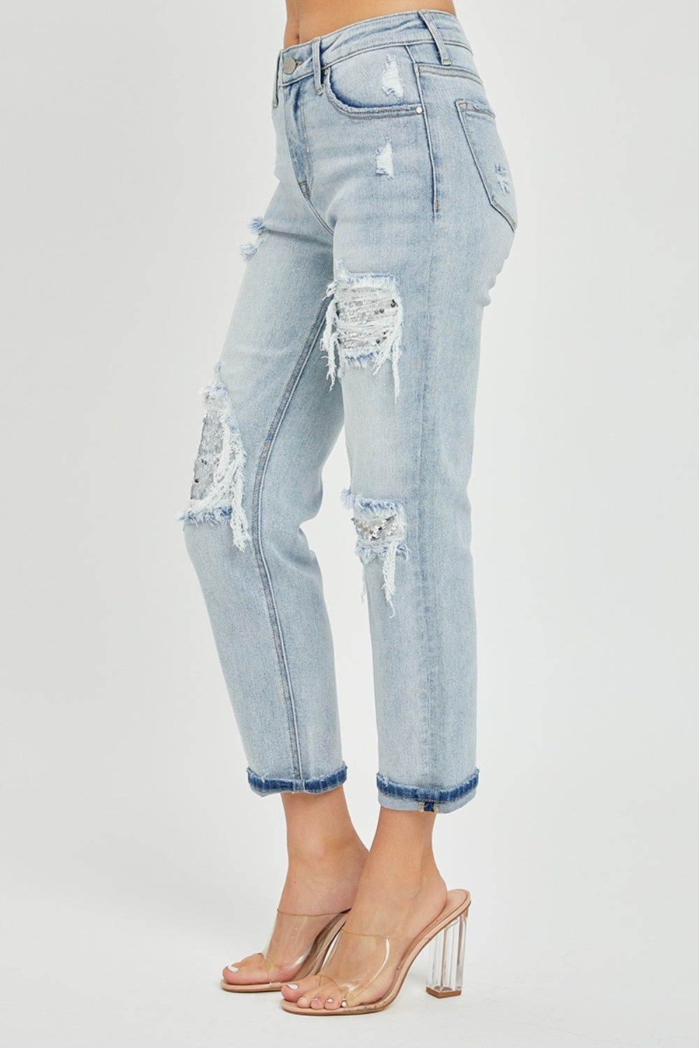 Person wearing RISEN Mid-Rise Sequin Patched Jeans and clear high-heeled sandals, against a plain background.