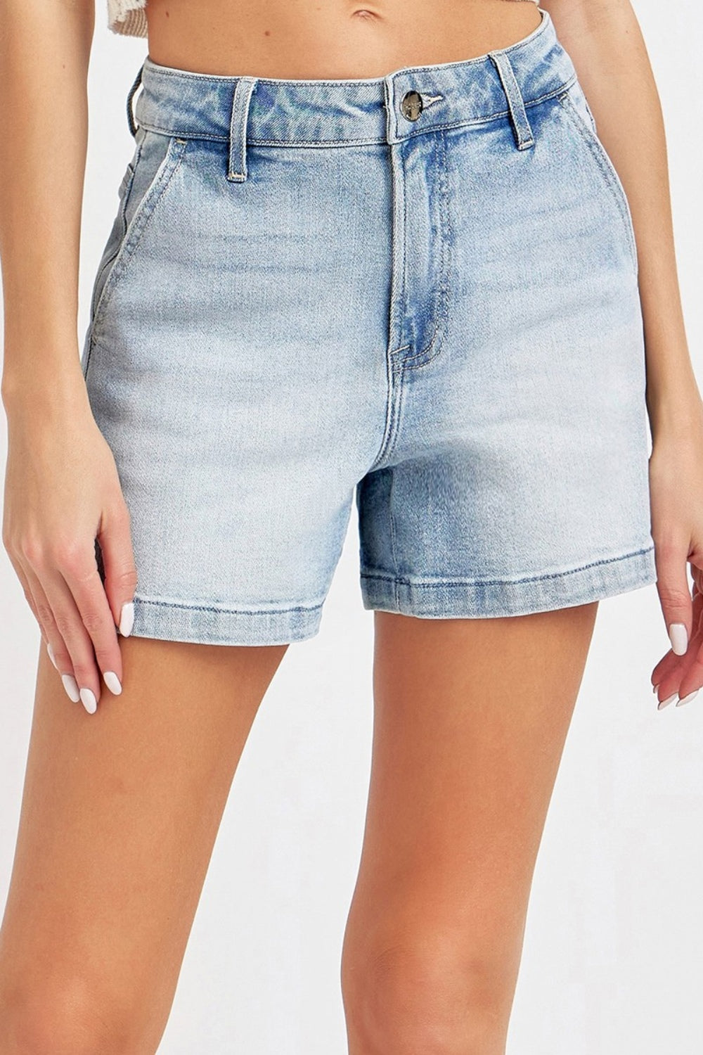 Someone wearing the Risen Full Size High Rise Denim Shorts in a light blue wash, featuring a button and zipper front, appreciates their flattering silhouette, making them a versatile wardrobe staple.