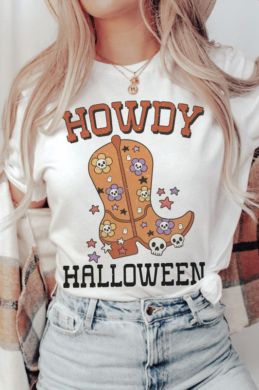 Person wearing the HOWDY HALLOWEEN Graphic Tee, a 100% cotton white t-shirt featuring the words "Howdy Halloween" along with a decorative boot embellished with skulls and flowers.