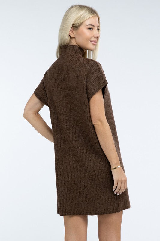 A woman stands wearing a brown Mock Neck Short Sleeve Sweater Dress with a pocket on the left side of the chest, paired with black ankle boots. She is posing against a plain white background.