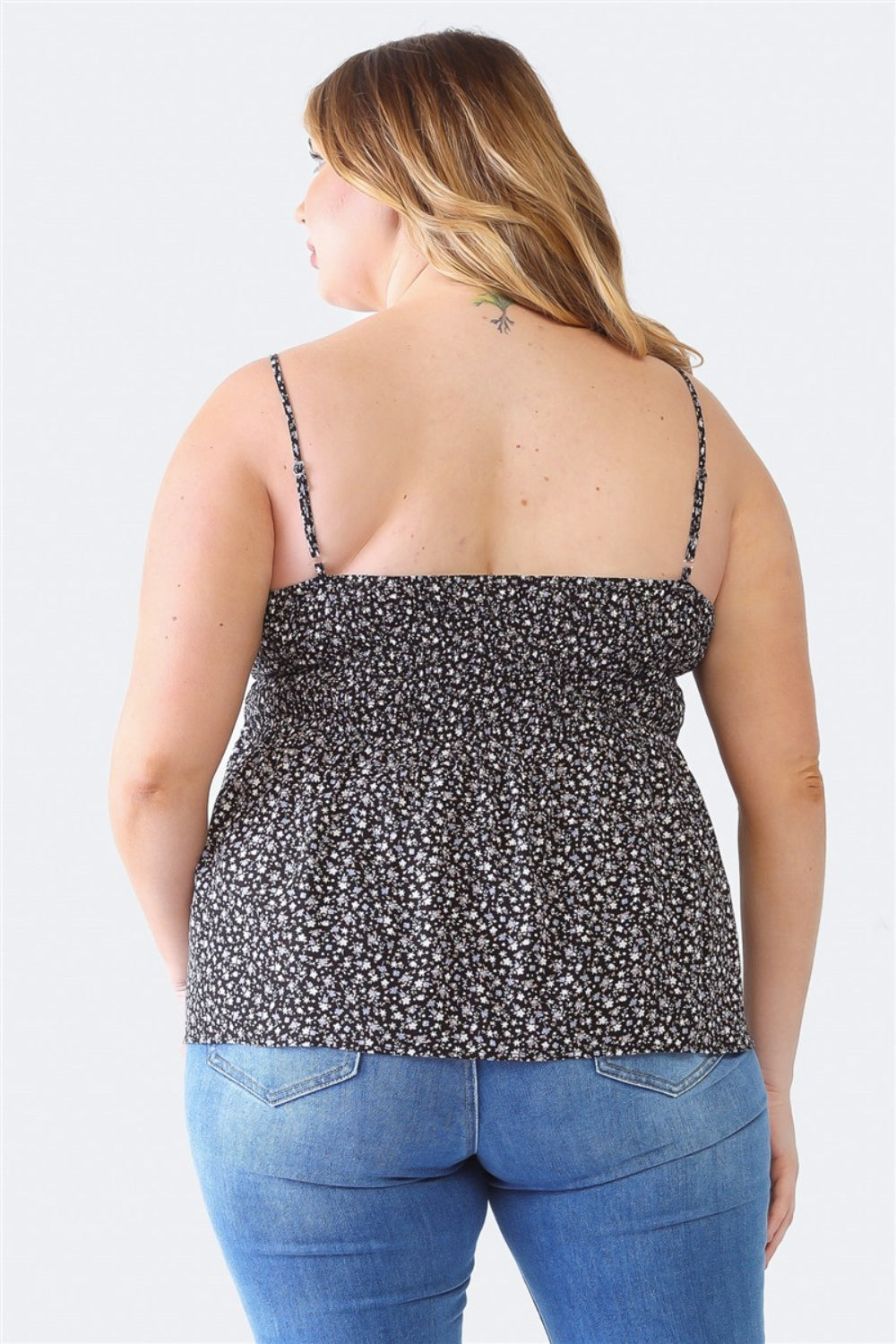 A woman stands facing the camera wearing a Zenobia Plus Size Frill Smocked Floral Sweetheart Neck Cami with dark jeans, against a plain background.