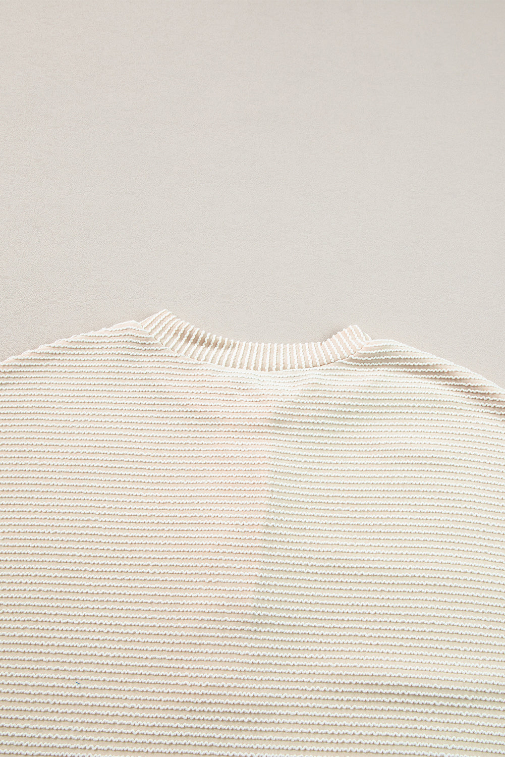 Person wearing the Apricot Corded Texture Lantern Sleeve Buttons Henley Sweatsuit and blue jeans, taking a mirror selfie with a smartphone. Hair is straight and shoulder-length; they stand in front of a white wall and a wooden chair.