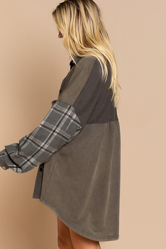 A person wearing the Long Sleeve With Plaid Detail Sleeve Shacket in brown, featuring plaid details on the sleeves and a matching pocket, paired with a white top underneath and a wide-brimmed hat—perfect for transitional weather.