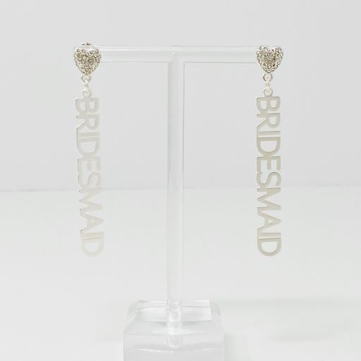 A pair of silver and a pair of gold-plated brass "Be My Bridesmaid" slogan earrings against a light background.