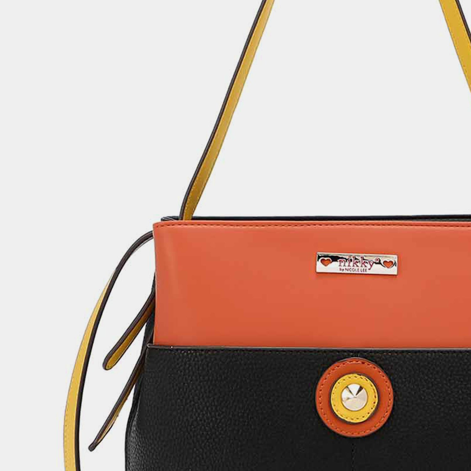 A Nicole Lee USA Contrast Leather Shoulder Bag in black and orange with yellow trim, featuring an adjustable shoulder strap, a circular logo on the front, and a small metal plaque near the top.