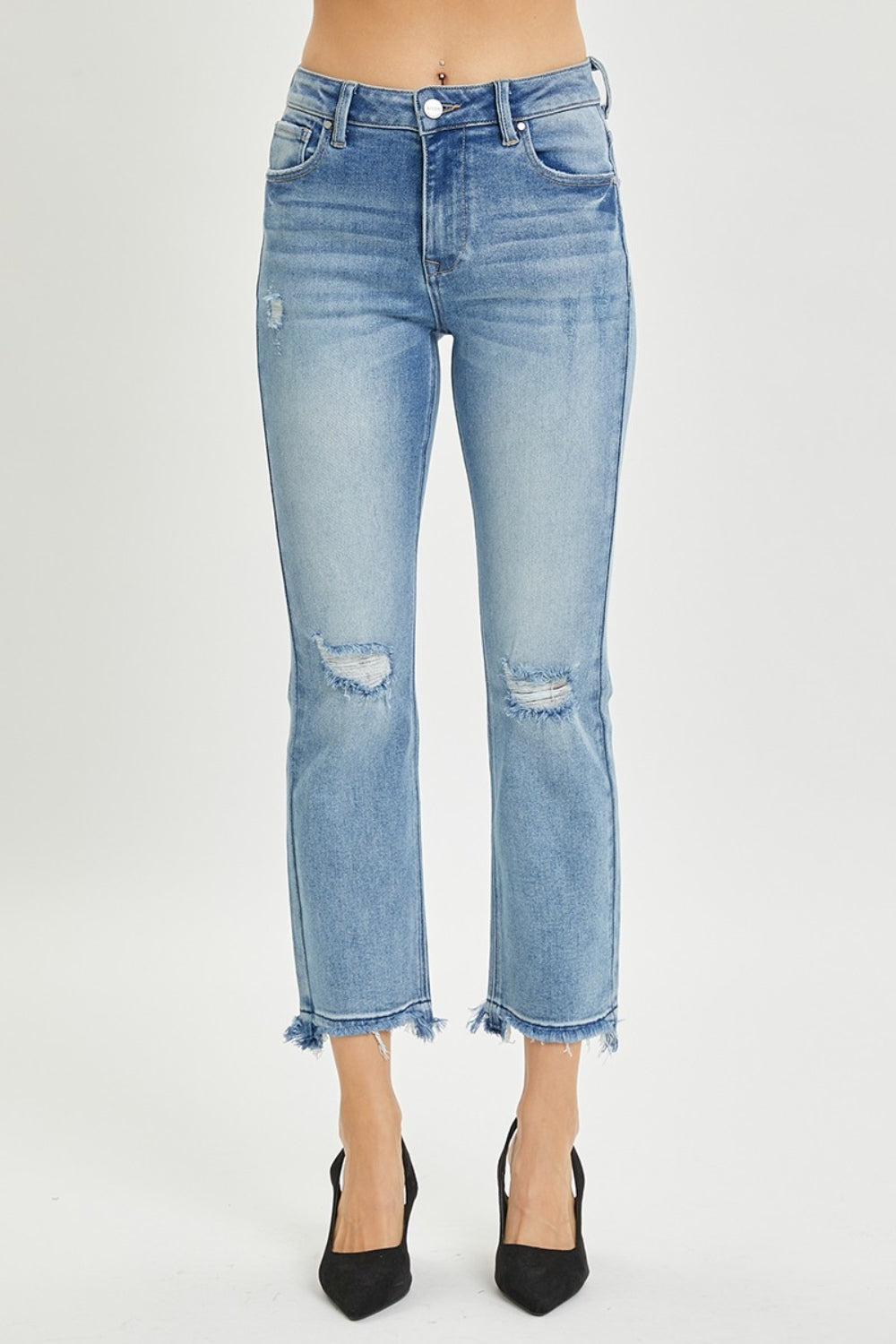 A person wearing the RISEN Full Size High Rise Distressed Cropped Straight Jeans in light blue with frayed hems, paired with black pointed-toe heels.