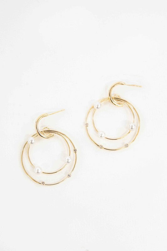 The Fawn Pearl Hoop Earrings, elegantly enhanced with pearls, gleam on a pristine white background, featuring lustrous 10k gold plating.