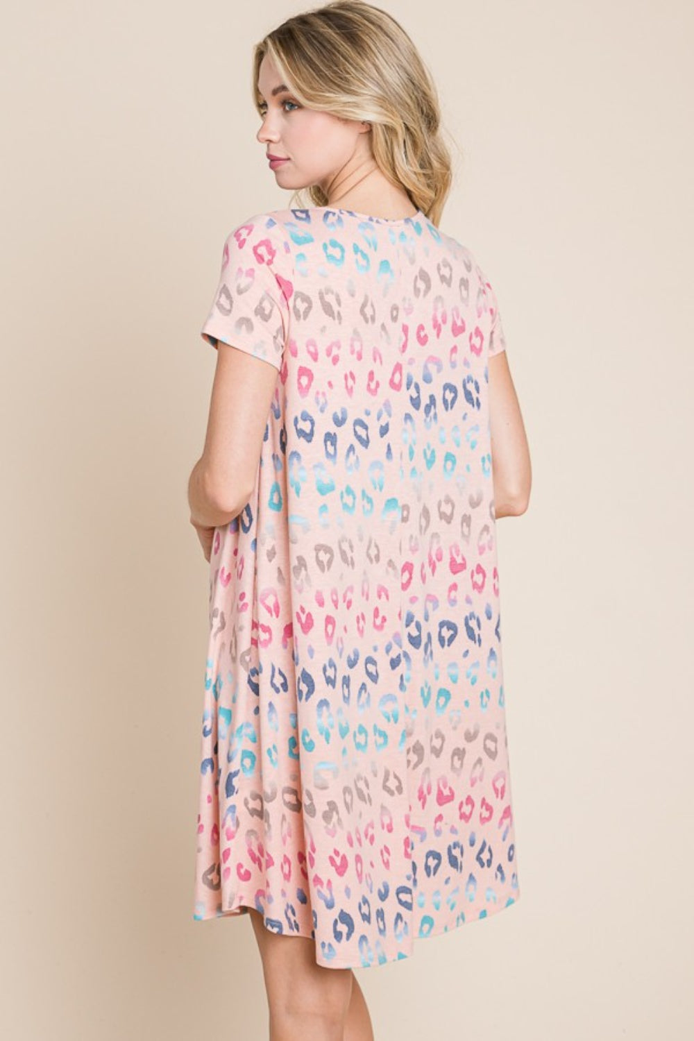 A woman wearing the BOMBOM Leopard Round Neck Short Sleeve Dress and a straw hat poses against a beige background.