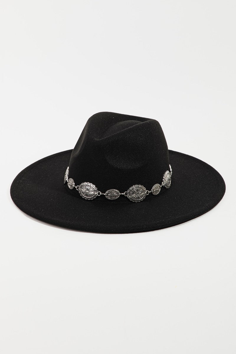 Wearing the Fame Metal Trim Flat Brim Fedora Hat with decorative accents, paired with a single-shoulder white top and layered necklaces, this person showcases the perfect blend of style and fashion accessory.