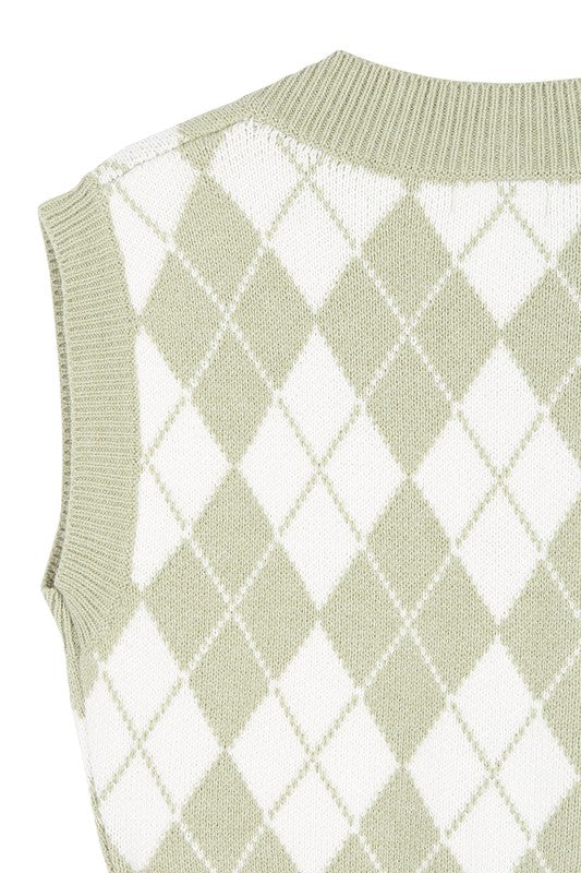 A person wearing a knitted argyle sweater vest in light green over a white shirt stands against a neutral background.