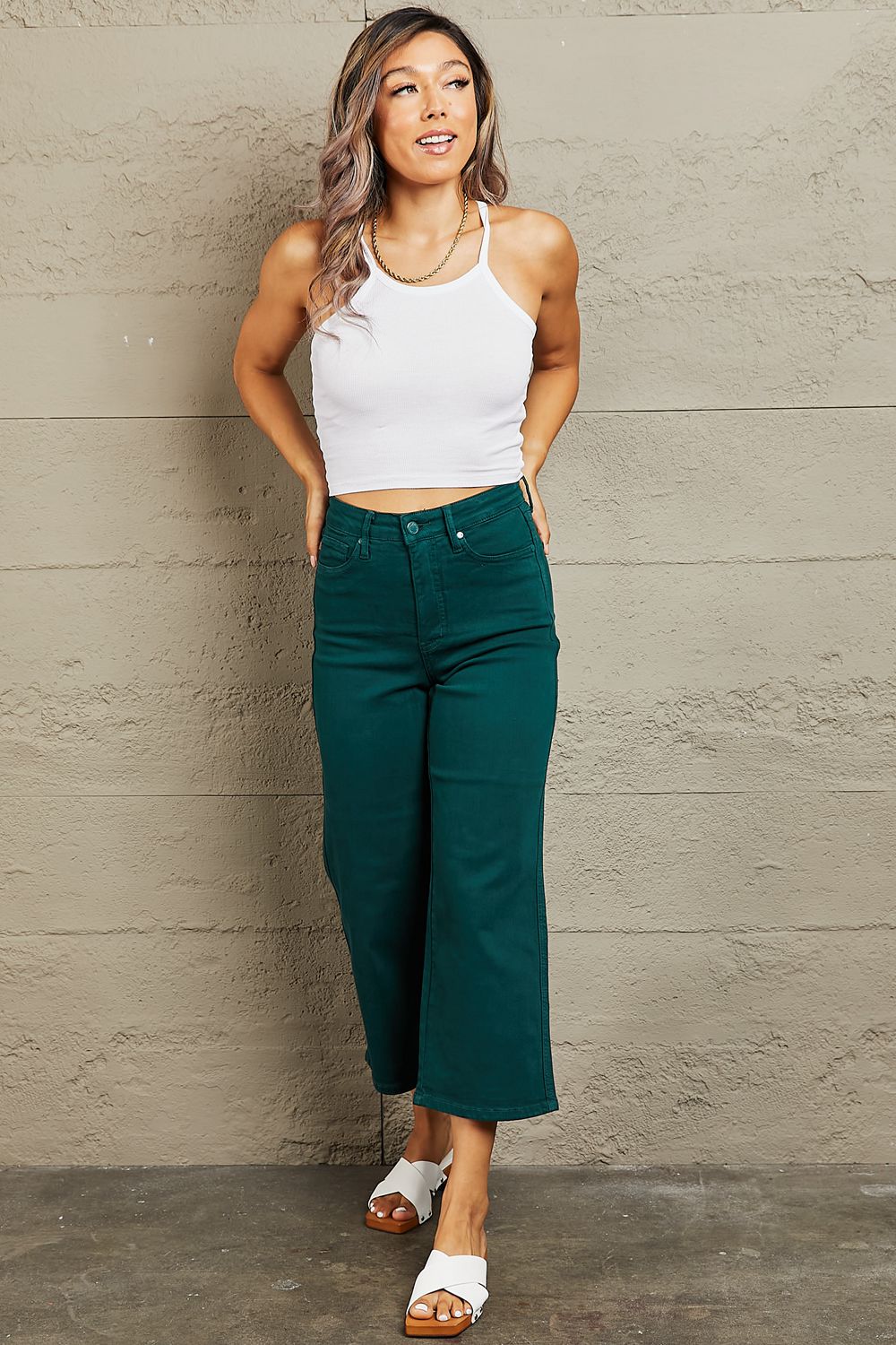 Person wearing Judy Blue Hailey Full Size Tummy Control High Waisted Cropped Wide Leg Jeans that offer subtle silhouette enhancement, paired with stylish white sandals.