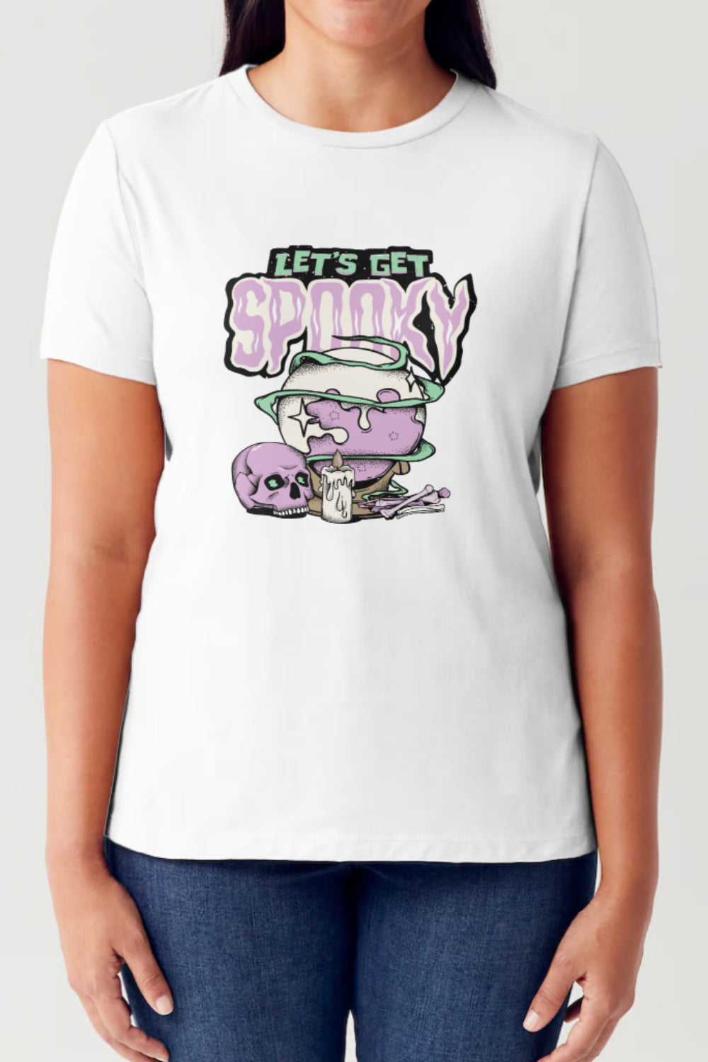 A person wearing the Simply Love Full Size LET'S GET SPOOKY Short Sleeve Tubular T-Shirt, featuring a white color with a graphic of a purple skull, a cauldron, and the text "LET'S GET SPOOKY." Perfect for festive gatherings!