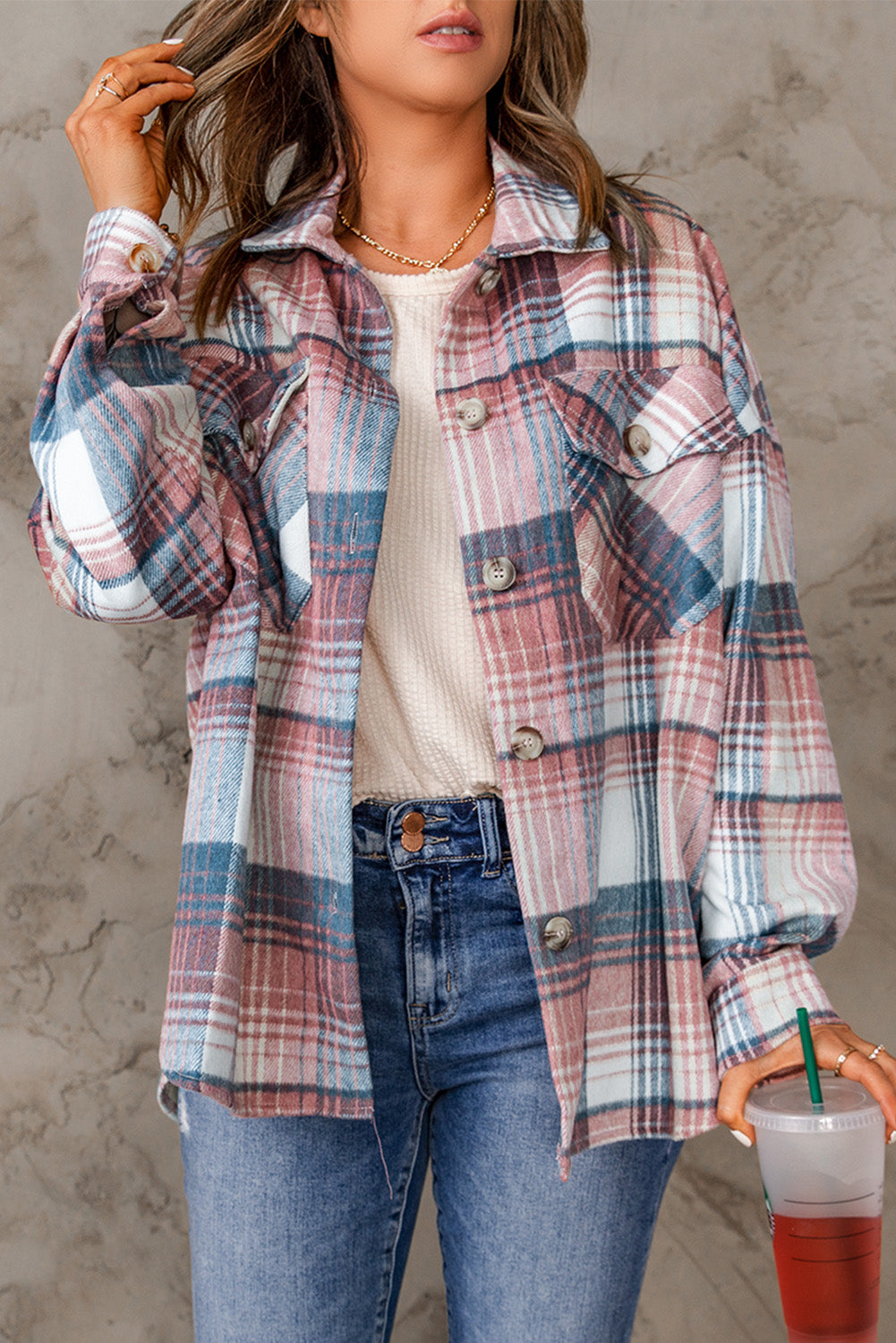 A woman wearing a white top, blue jeans, and the Gold Flame & Grey Plaid Button Up Collared Flannel Shacket smiles while posed outdoors.