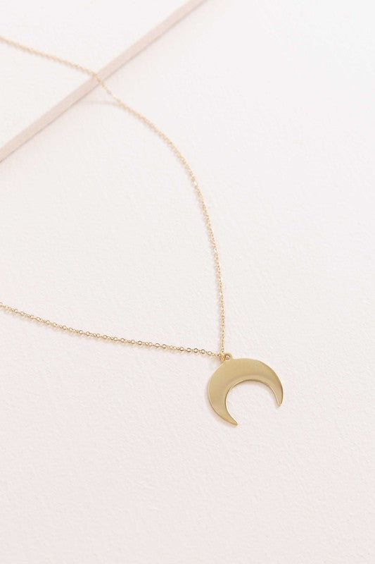 A delicate Moonglade Necklace 14K Gold with a crescent moon charm pendant displayed on a white surface.