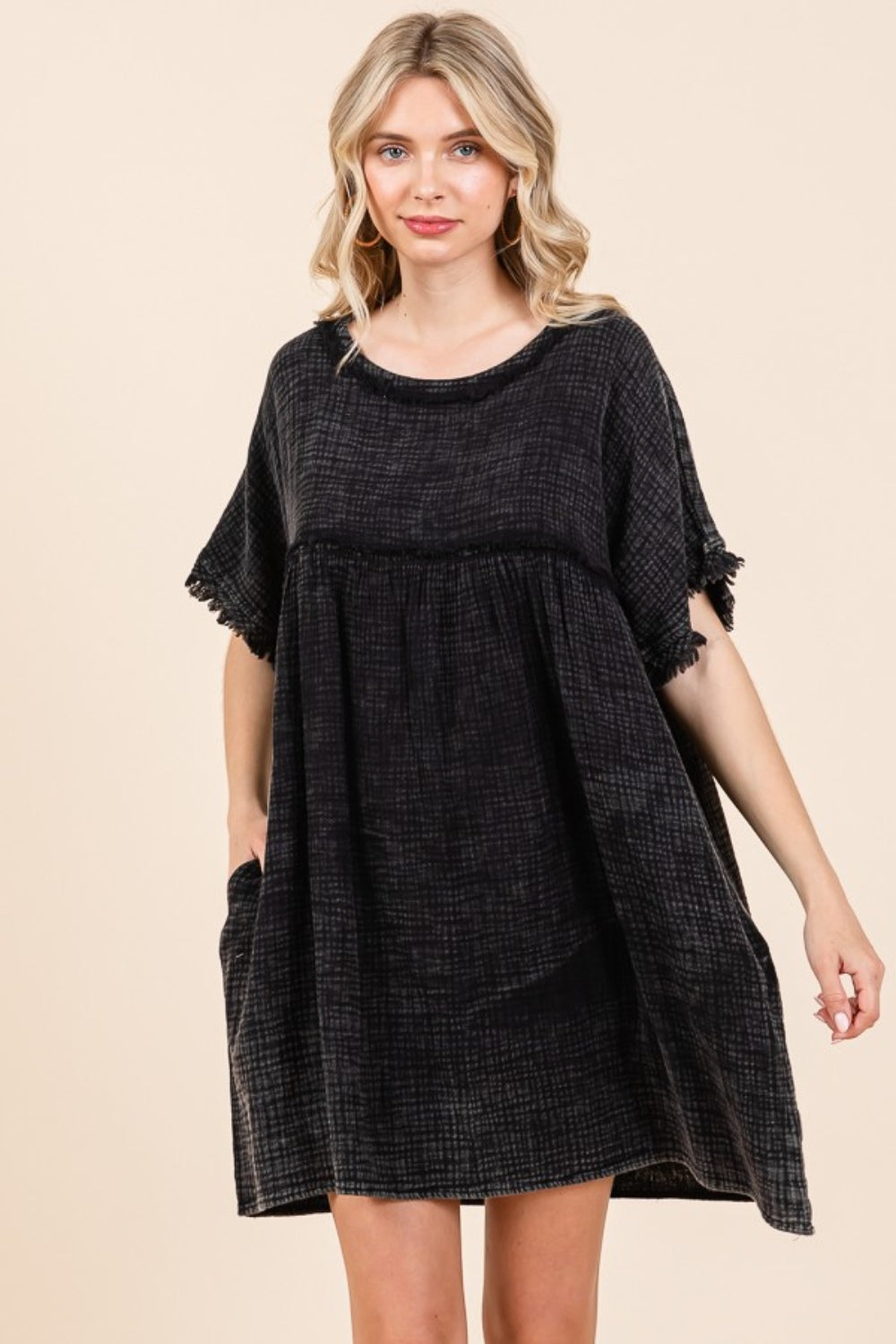 A person is wearing the Culture Code Full Size Short Sleeve Babydoll Texture Dress with Pockets, in black, standing against a plain background.