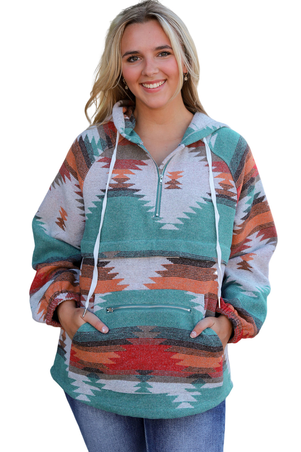 A woman with long blonde hair is standing outside, facing away from the camera. She wears a Multicolor Aztec Print Zipped Split Neck Hoodie and jeans. A rug and potted plant are visible in the background, adding to the cozy vibe of her super comfortable outfit.