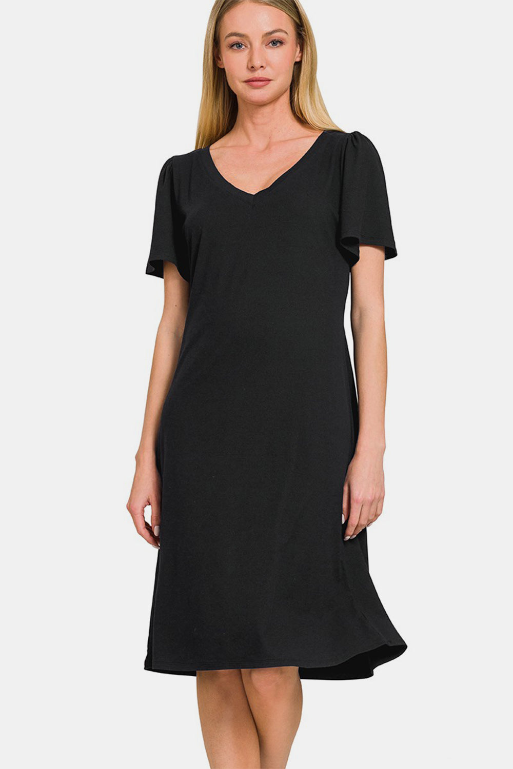 A woman with straight blonde hair, wearing a versatile and timeless Zenana V-Neck Short Sleeve, knee-length black dress.