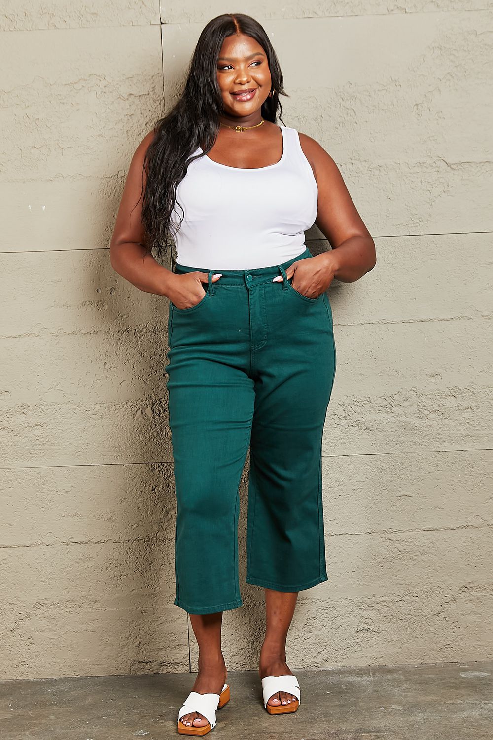 Person wearing Judy Blue Hailey Full Size Tummy Control High Waisted Cropped Wide Leg Jeans that offer subtle silhouette enhancement, paired with stylish white sandals.