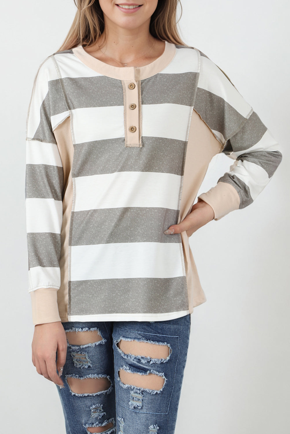 A person wearing a Multicolor Striped Colorblock Patchwork Sweatshirt paired with distressed blue jeans.