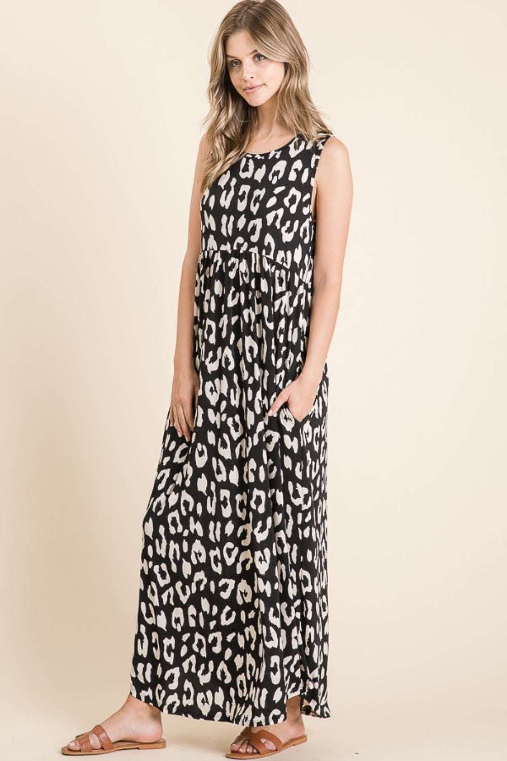 A person wearing the BOMBOM Leopard Maxi Dress with Pockets, paired with brown sandals, is standing against a beige background.