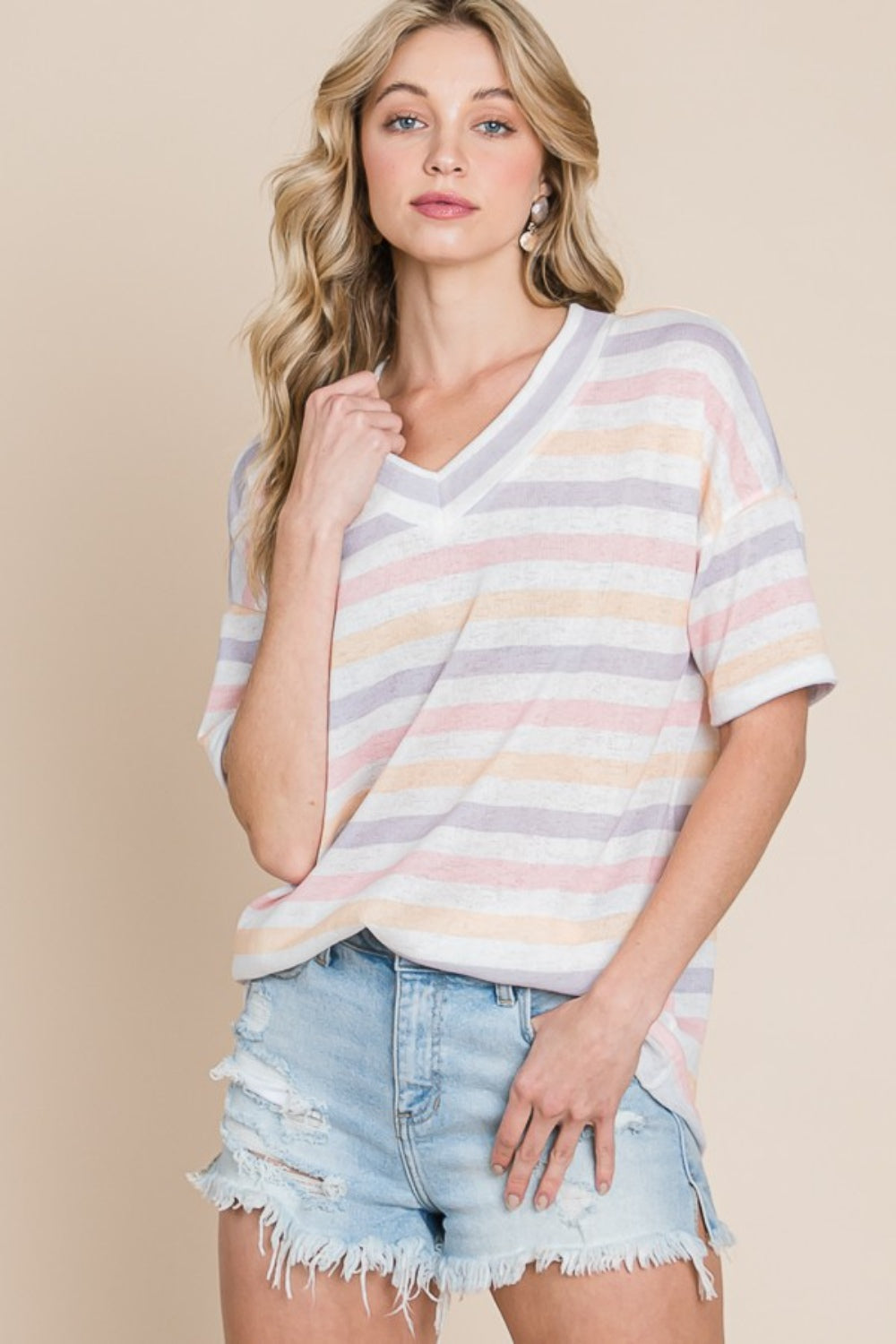 A woman in casual wear dons a BOMBOM Striped V-Neck Short Sleeve T-Shirt and light denim shorts, standing against a plain background.