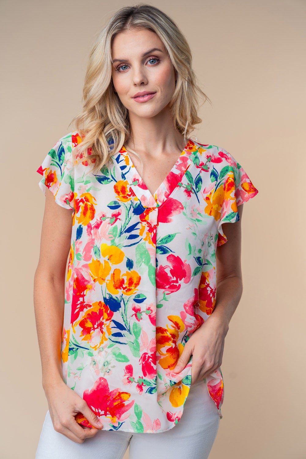 A woman wearing a White Birch Full Size Short Sleeve Floral Woven Top stands against a neutral background.