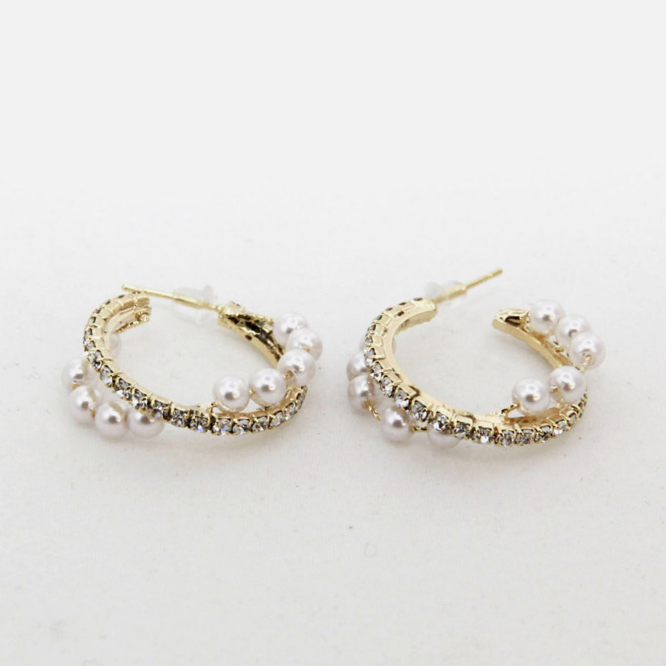 Alloy Pearl Hoop Earrings featuring gold hoops with imitation pearls and small clear gemstones, showcased on a vertical stand.