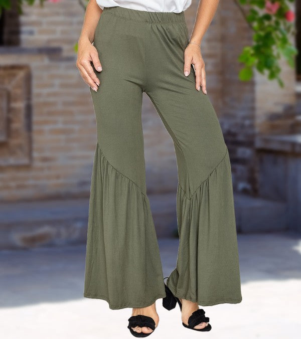 A person wearing olive green Diagonal Trim Ruffle Hem Pants with wide-leg, flared bottoms, made from a comfortable blend of rayon and spandex, stands outdoors on a paved area.
