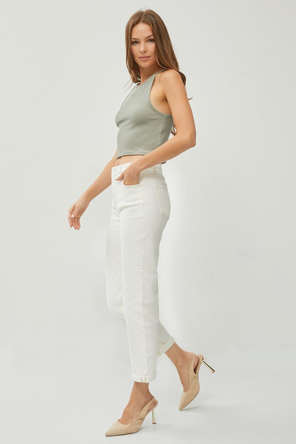 Description: Person wearing RISEN Full Size High Waist Rolled Hem Straight Jeans in white with beige heels against a plain background. 