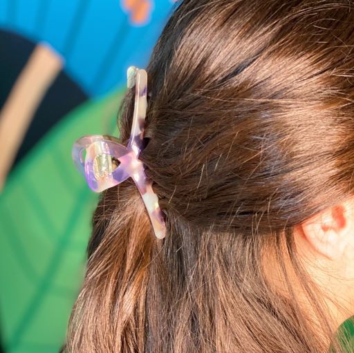 Two different colored Barely There Hair Claws placed on a light-colored surface.
