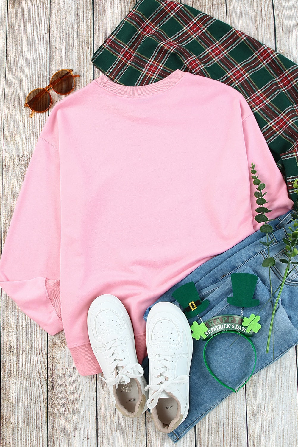 Individual with wavy brown hair wearing a Pink Plain Crew Neck Pullover Sweatshirt and blue jeans, standing with their back to the camera.