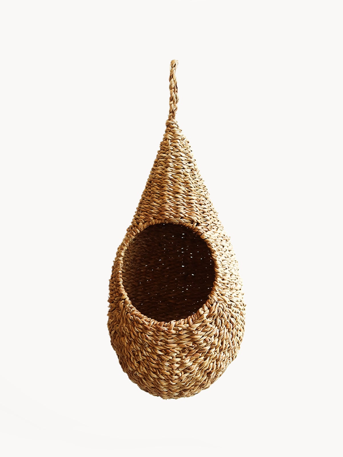 The teardrop-shaped Savar Pot Planter, handwoven from seagrass by Fair Trade artisans, showcases an open circular entrance against a plain white background.