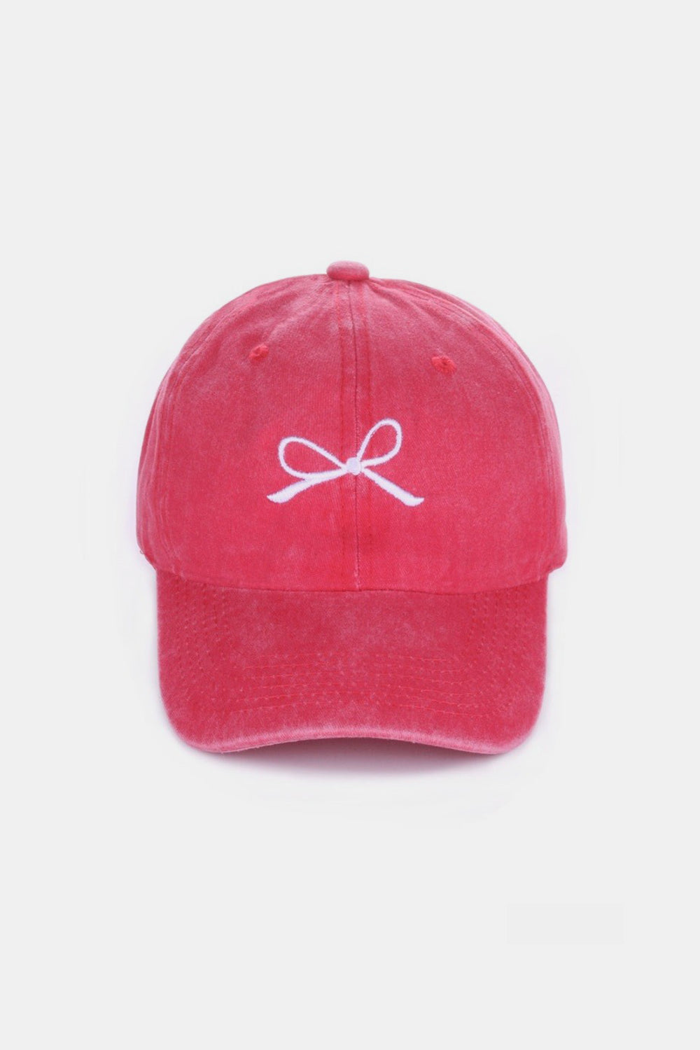 The Zenana Bow Embroidered Washed Cotton Cap features a pink design with a stylish white bow on the front, set against a plain, light background. This chic accessory seamlessly combines elegance and sportiness.