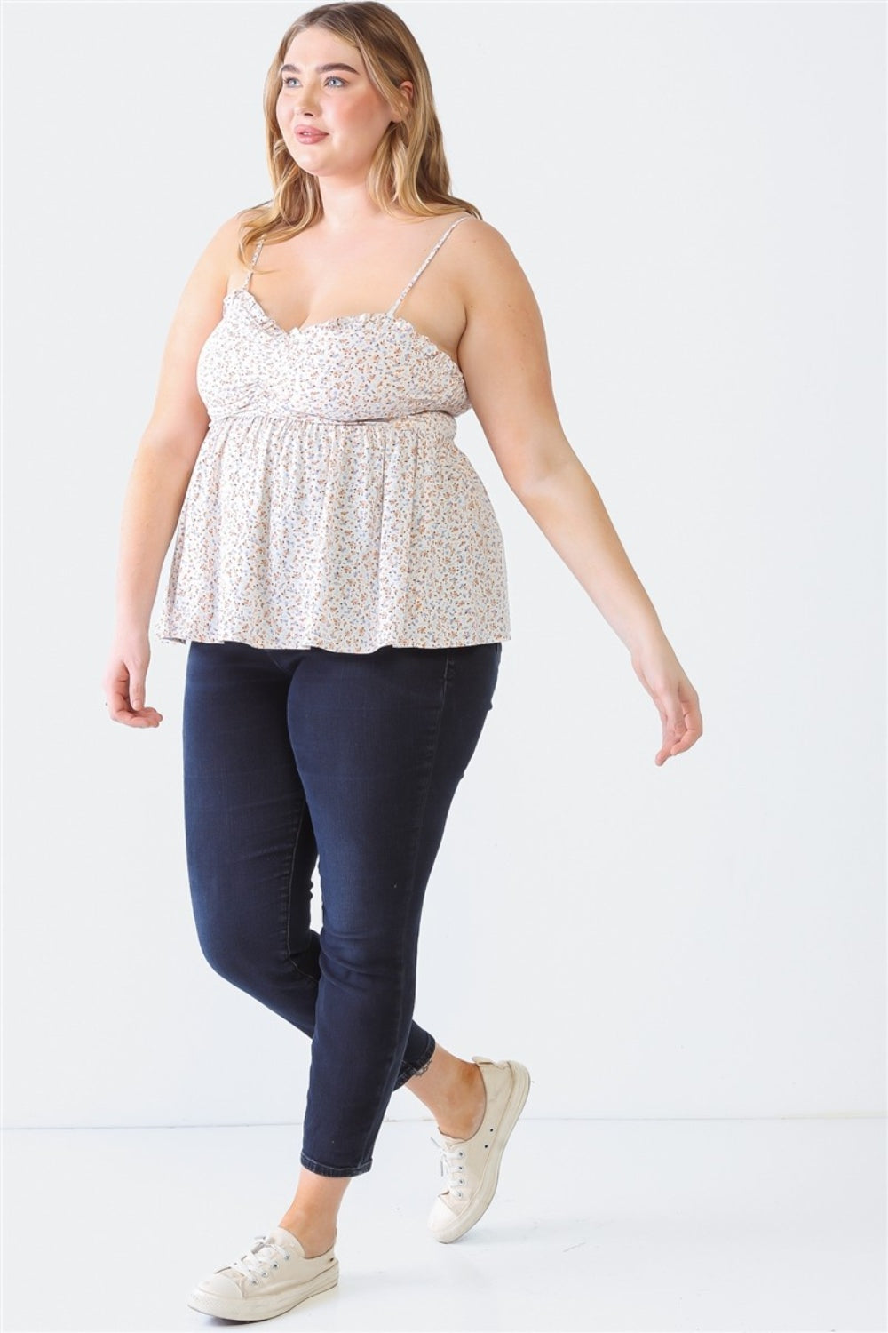 A woman stands facing the camera wearing a Zenobia Plus Size Frill Smocked Floral Sweetheart Neck Cami with dark jeans, against a plain background.