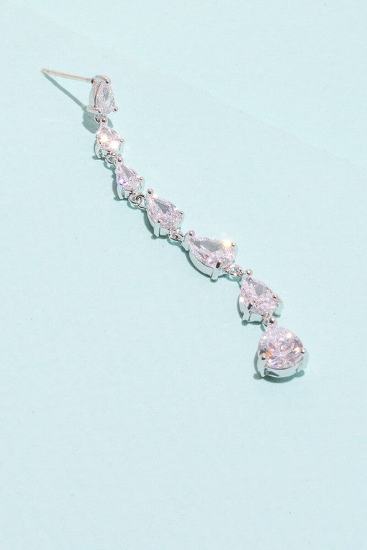 A pair of Droplet Wonder Dangle Earrings with red gemstones and sterling silver posts on a light background.