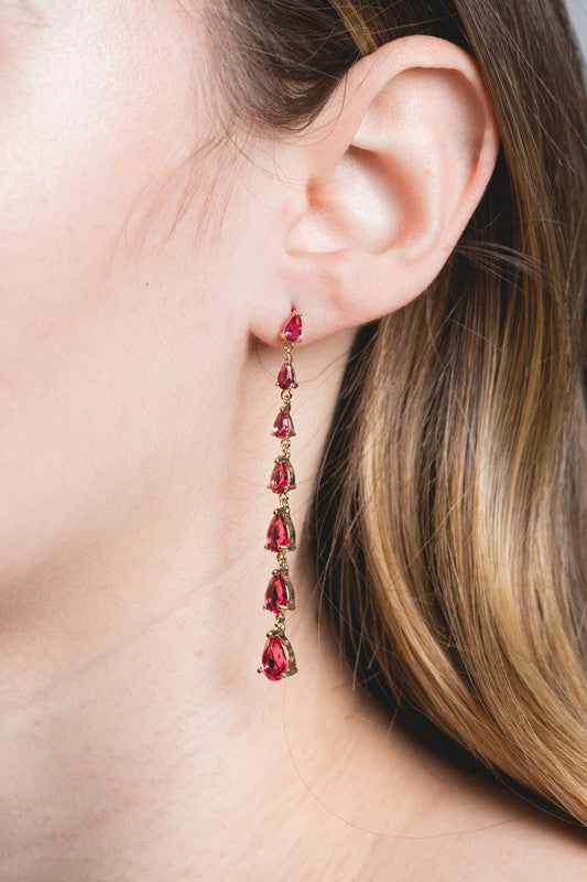 A pair of Droplet Wonder Dangle Earrings with red gemstones and sterling silver posts on a light background.