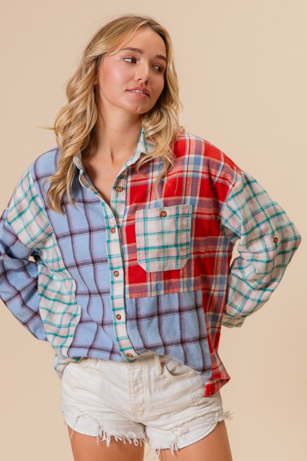 A person wearing a vibrant BiBi Color Block Plaid Button Down Shirt and white denim shorts stands against a neutral background.