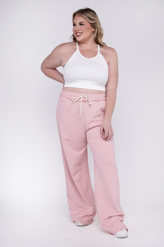 A person wearing the Plus F/Terry Drawstring Waist Raw Edge Hem Pants in pink, paired with white shoes, stands against a plain background.