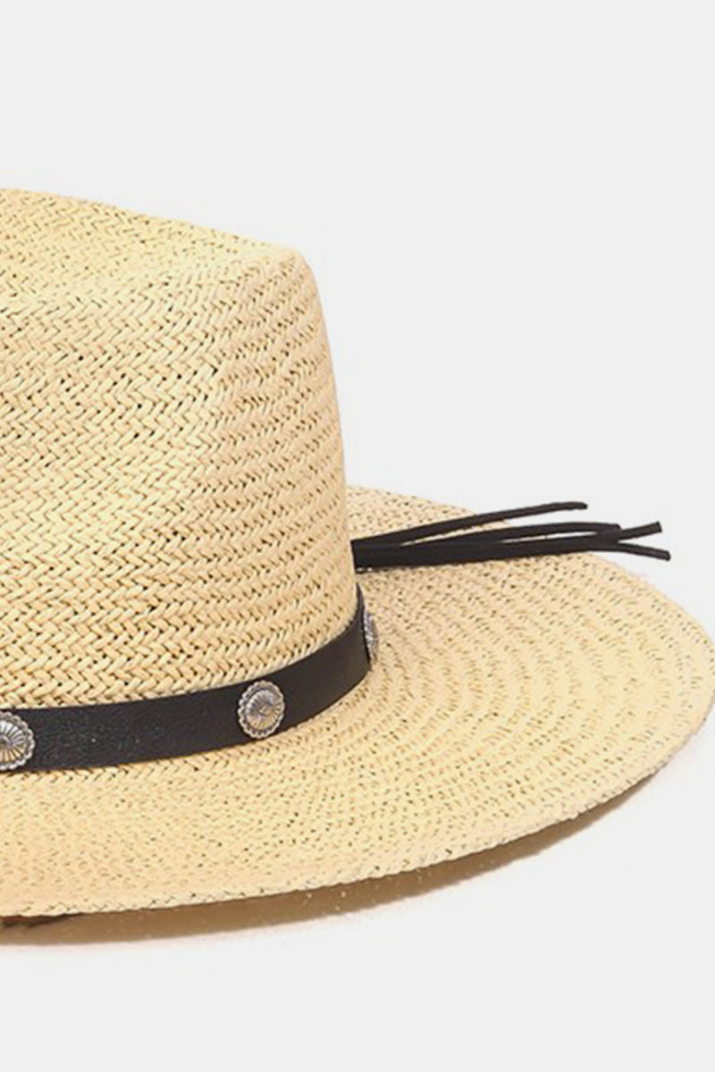 Introducing the Fame Belt Strap Straw Hat, a stylish accessory with a wide brim accented by a black band and decorative silver buttons, ideal for enhancing your summer wardrobe on a plain white background.