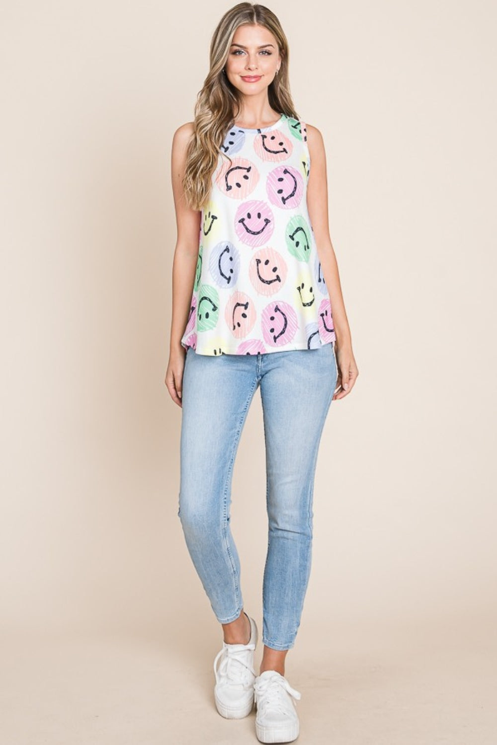 Wearing a BOMBOM Smiley Face Round Neck Tank, she poses comfortably with a warm smile in a casual and stylish outfit.