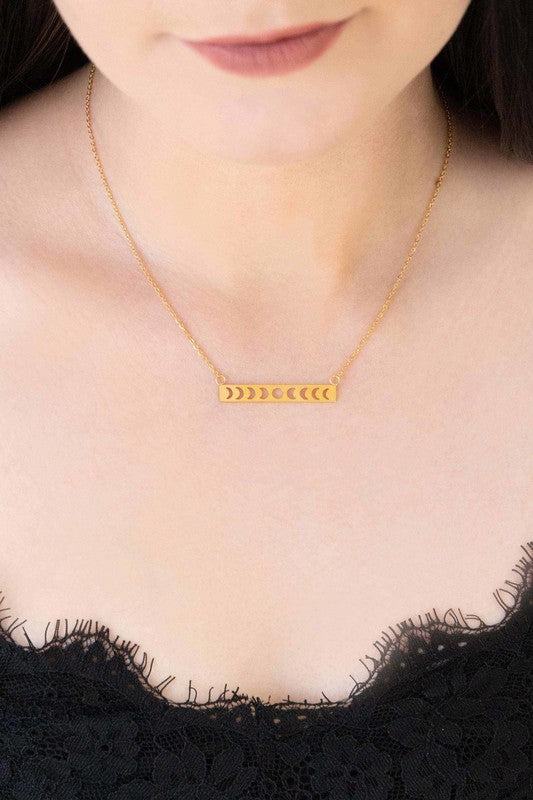 Lunar Phase Bar Necklace with an 18K gold over stainless steel bar pendant on a white background.