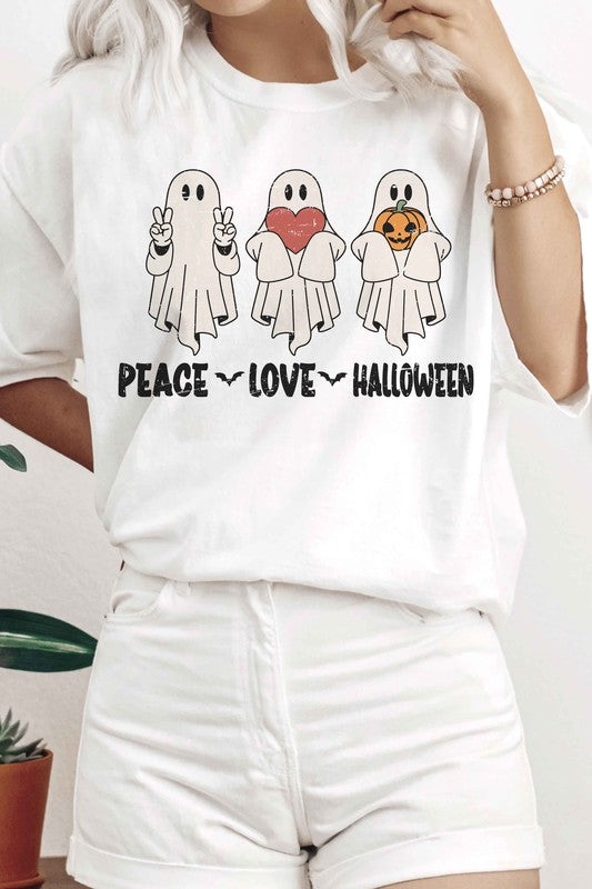 A person wearing the PEACE LOVE HALLOWEEN Graphic Tee, which features three cartoon ghosts—one making a peace sign, another holding a heart, and the third with a pumpkin—along with the words "PEACE LOVE HALLOWEEN" printed underneath.