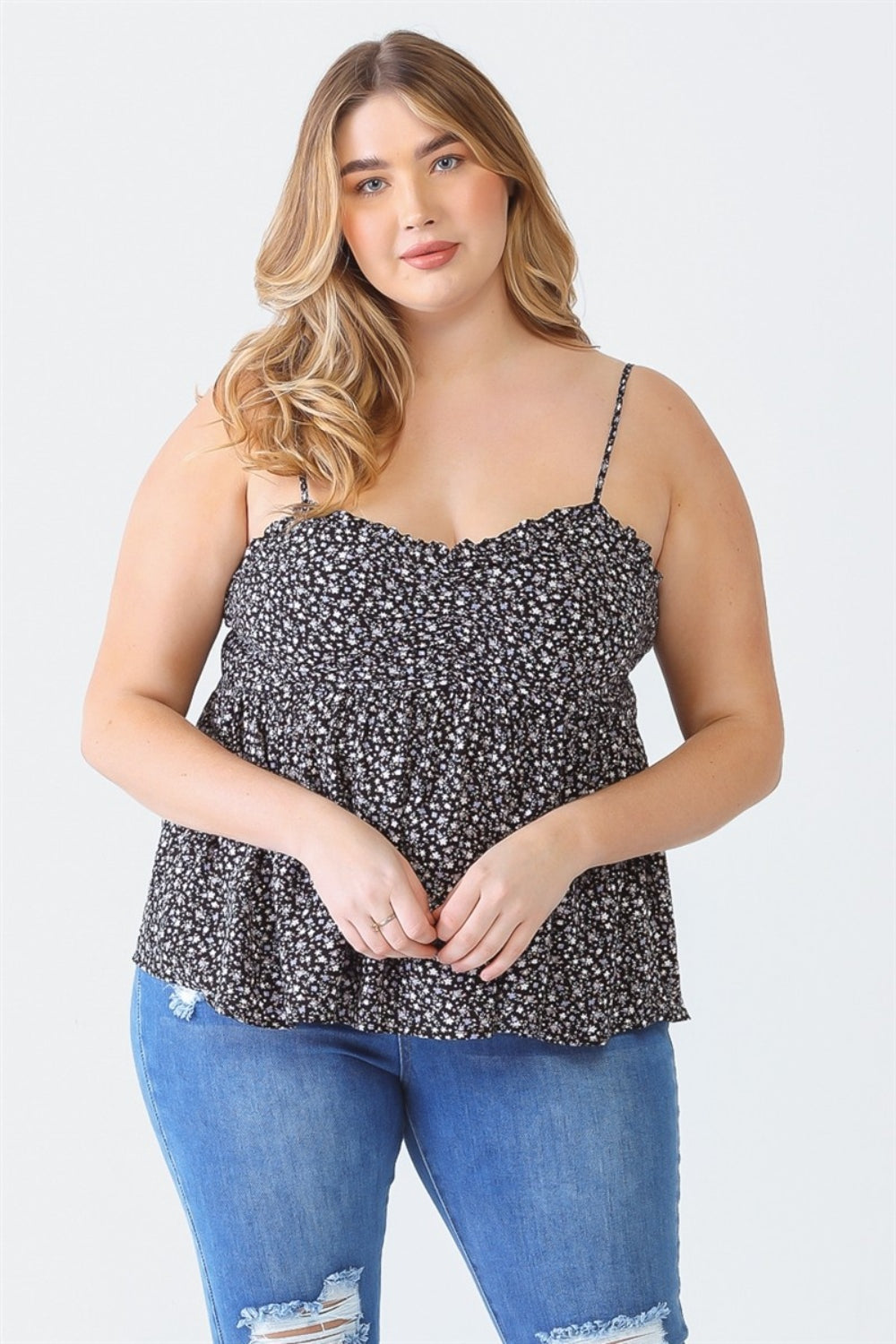 A woman stands facing the camera wearing a Zenobia Plus Size Frill Smocked Floral Sweetheart Neck Cami with dark jeans, against a plain background.